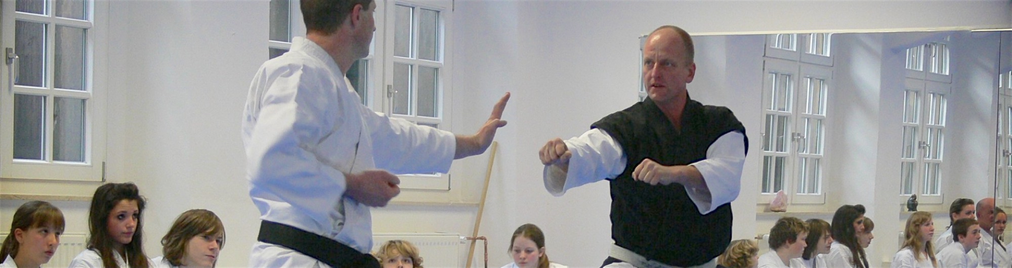 Zwei Karate Kampfkünstler stehen sich aufmerksam gegenüber