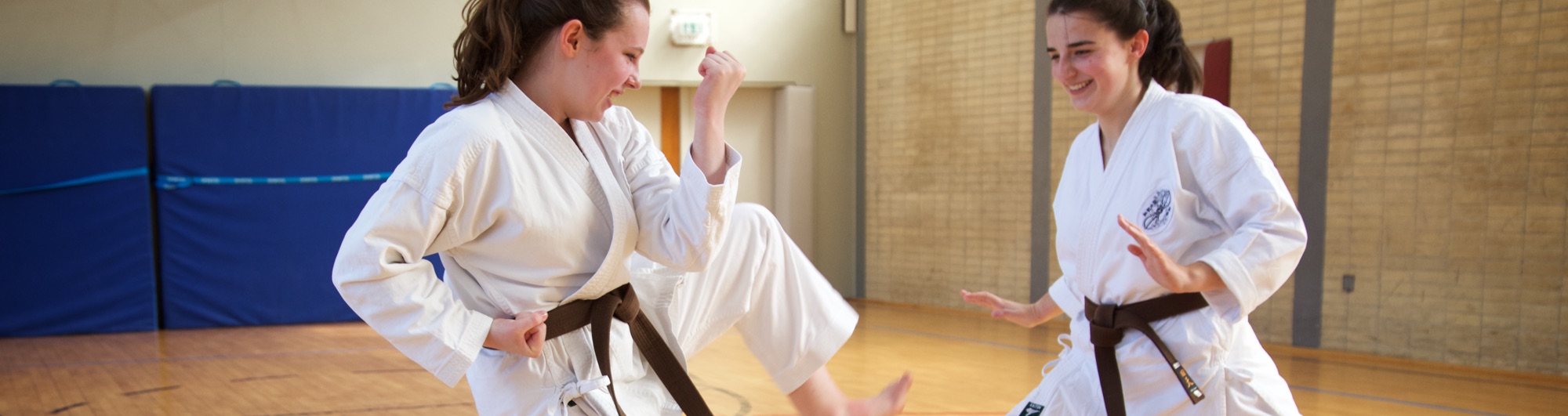 Zwei junge Frauen haben Spaß beim Karate Training